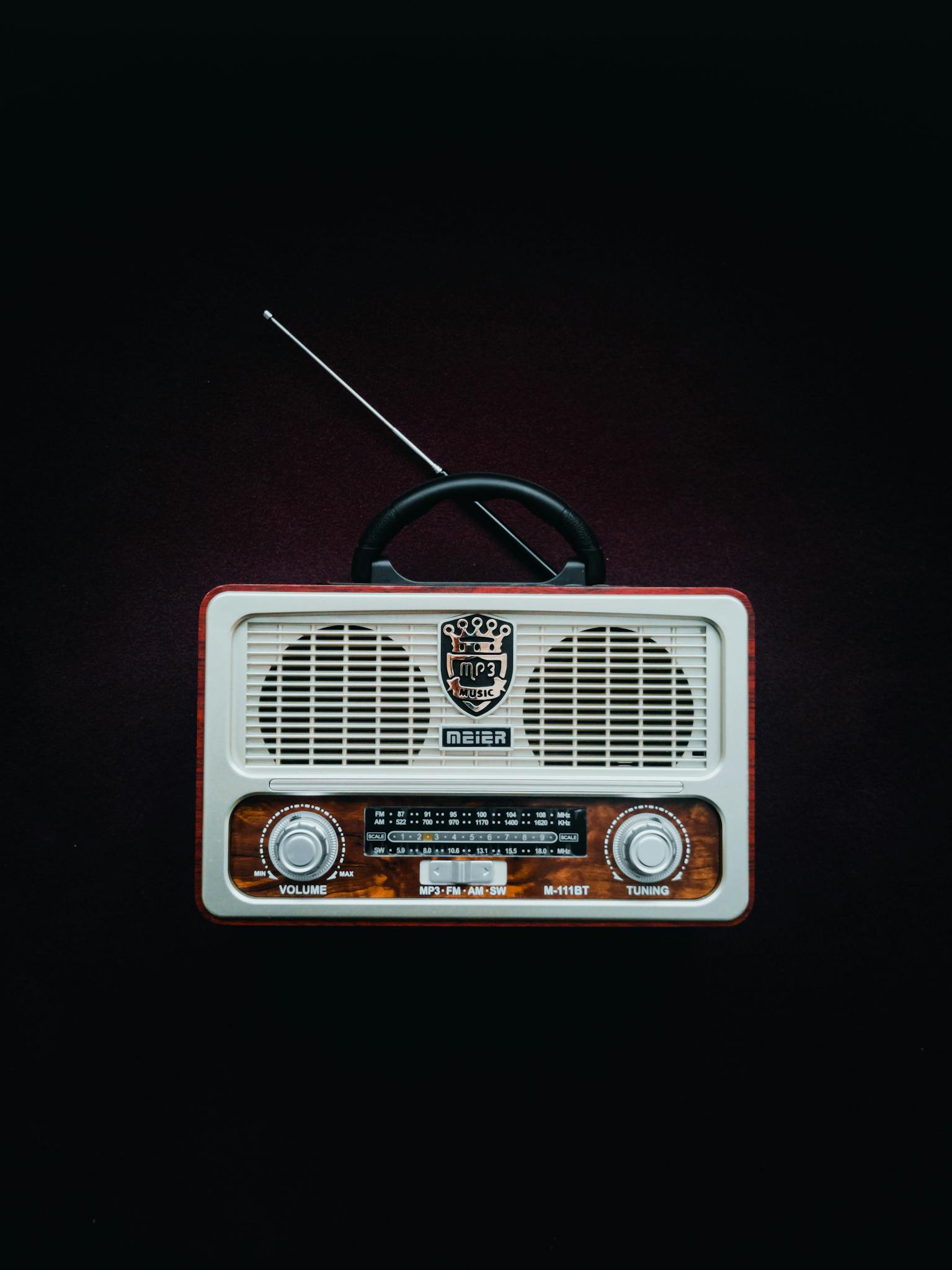 Classic retro radio with antenna and old-school dials on a dark backdrop, emphasizing vintage style.