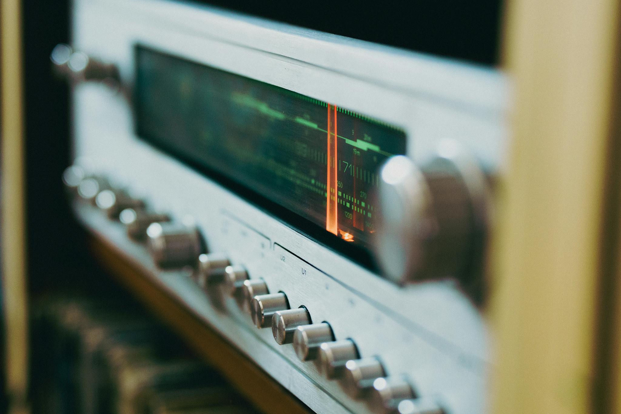 Close-up of an antique radio tuner with knobs and a retro display, evoking a classic analog feel.